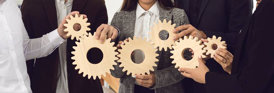 Grupo de colegas de trabalho segurando engrenagens