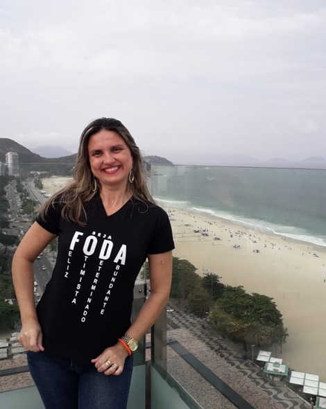 Melissa na sacada de um apartamento com vista para praia.