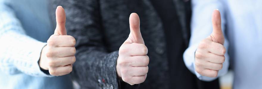 Grupo de pessoas fazendo sinal de positivo com a mão